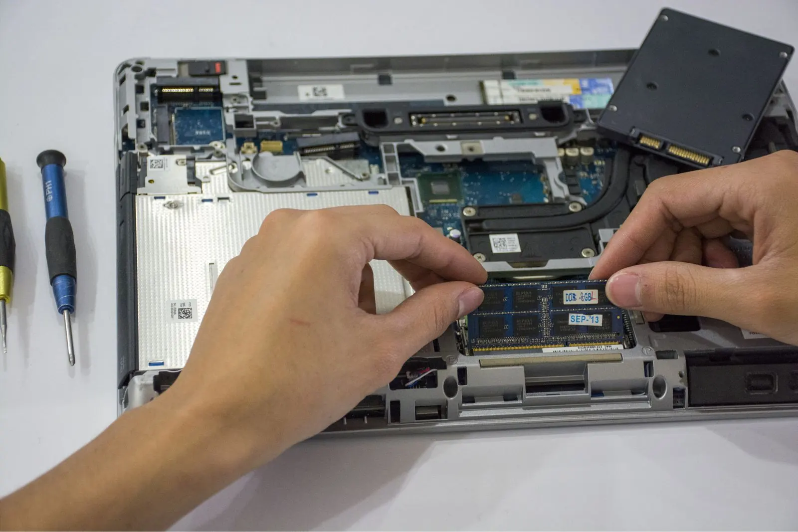Mains remplaçant un composant à l’intérieur d’un ordinateur portable